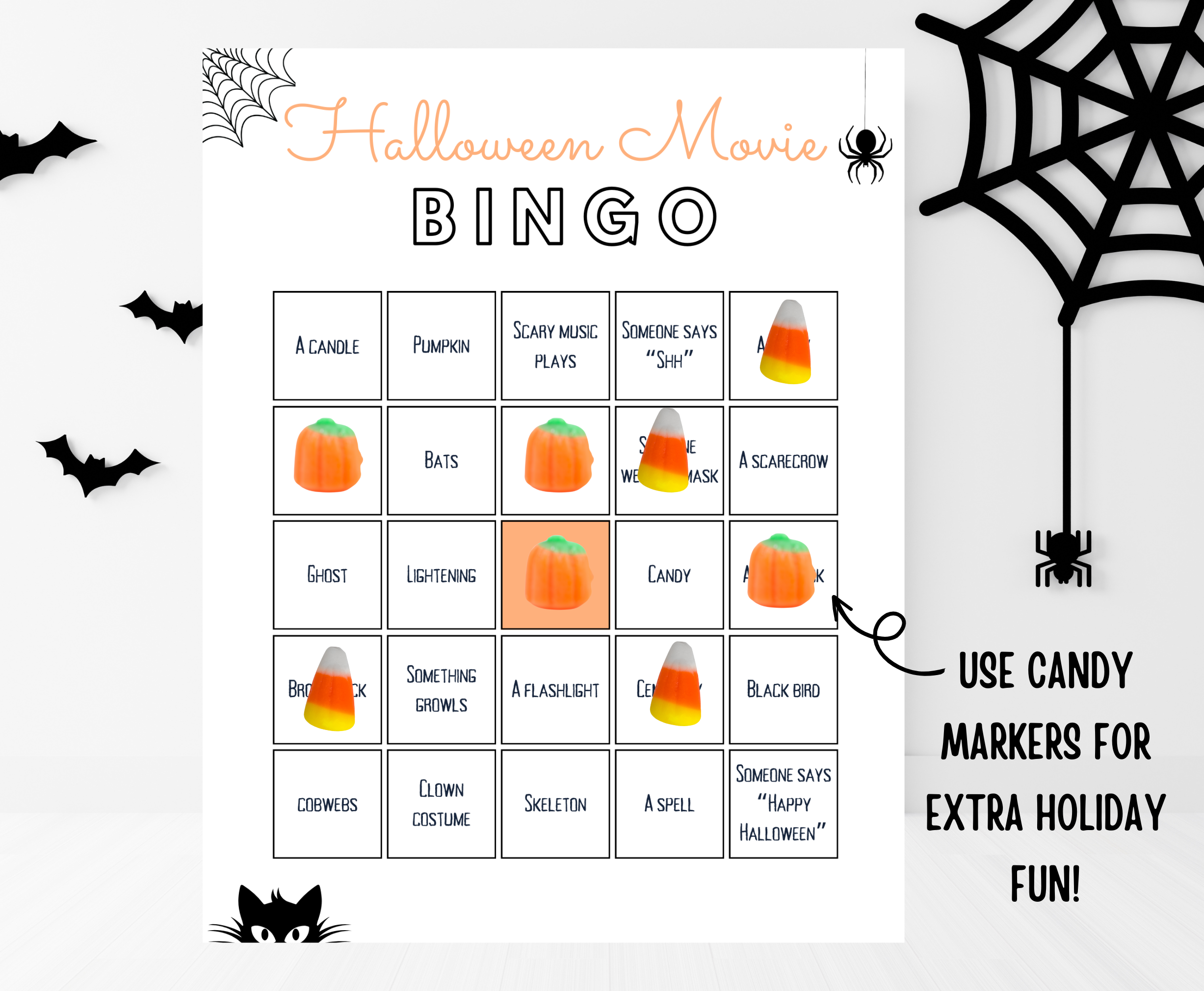 Halloween movie bingo card with candy corn and pumpkin candy markers on top